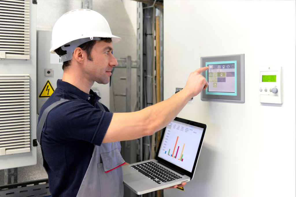 man in factory touching a panel pc or monitor