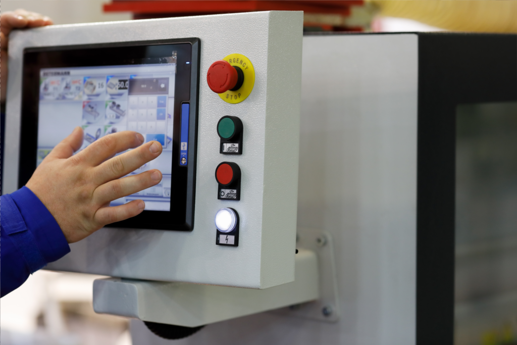 man in factory touching a panel pc or monitor