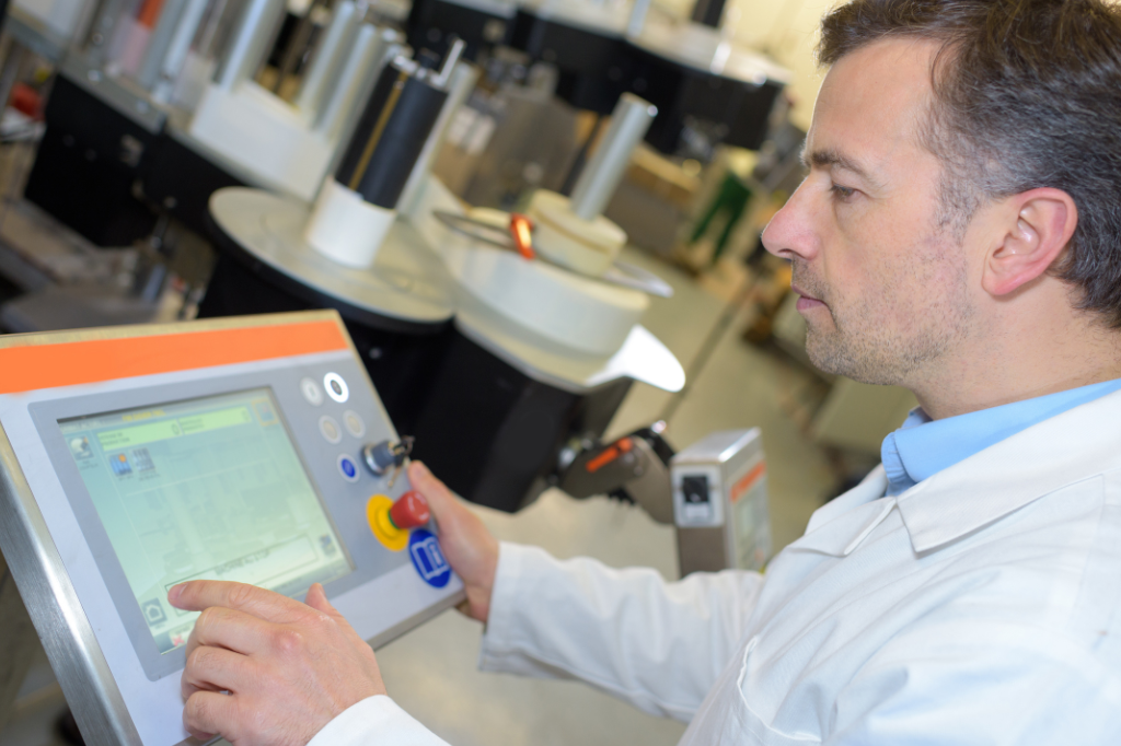 man in factory or lab touching monitor
