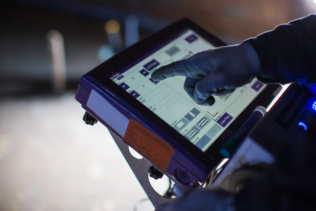 Male worker inspecting touch screen floor monitor scan bottom