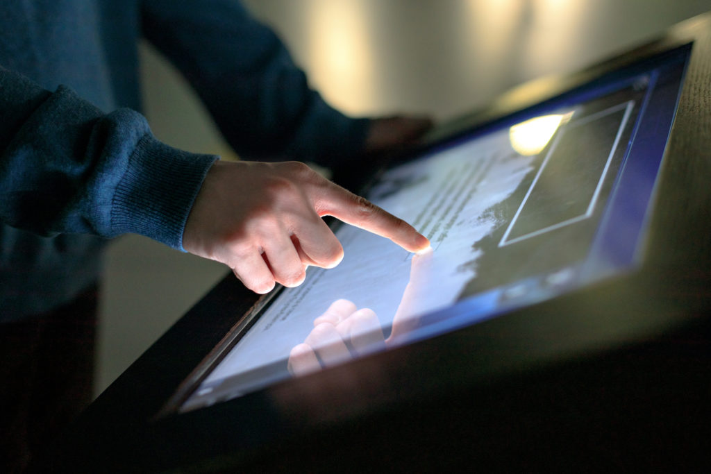 A boy uses the interactive touchscreen of an electronic multimed
