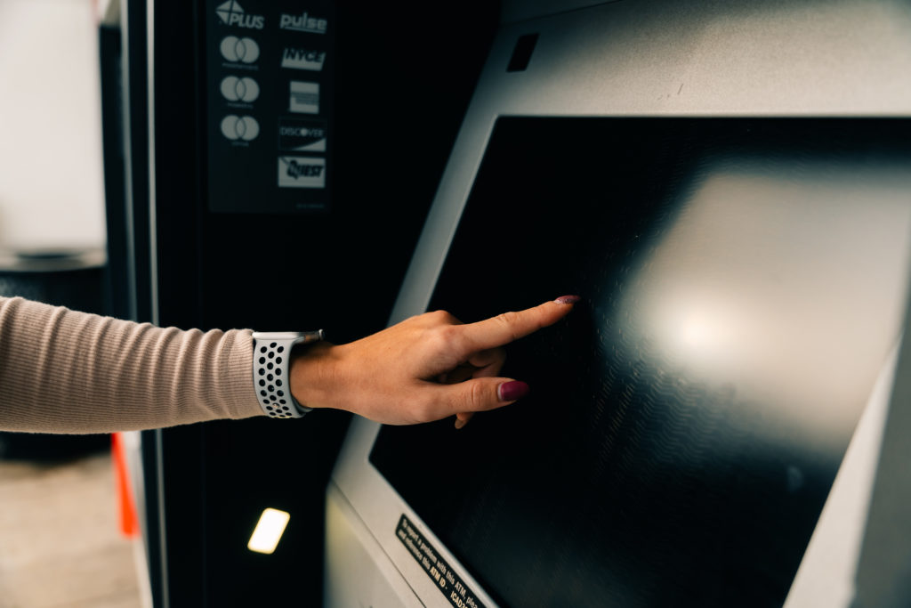 girl clicks on the screen at the ATM. High quality photo