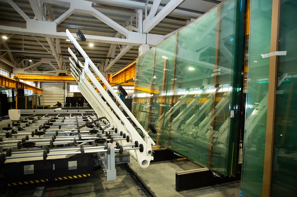 machines working with giant glasses in industrial glass window production factory.